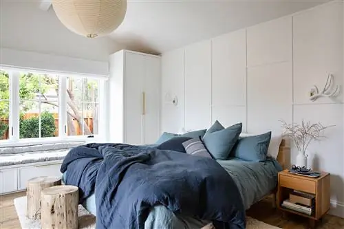 спальня с лепниной изголовья в белом цвете