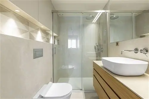 облицованная камнем ванная комната с душем и неподвижной перегородкой