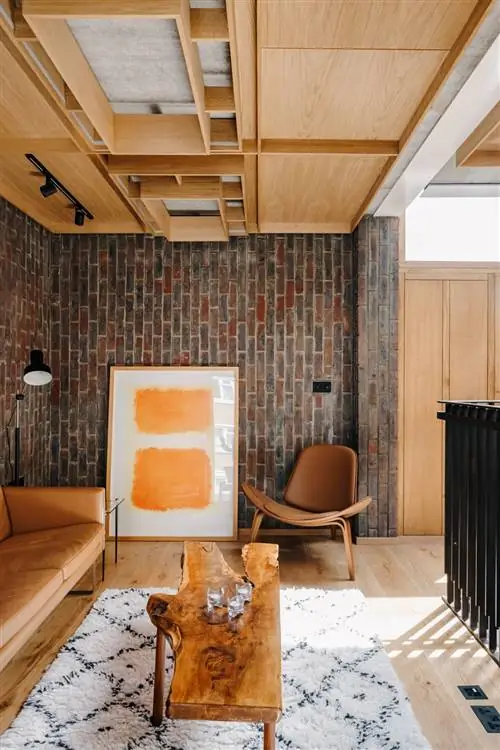 гостиная с кирпичными стенами и деревянным полом и потолком