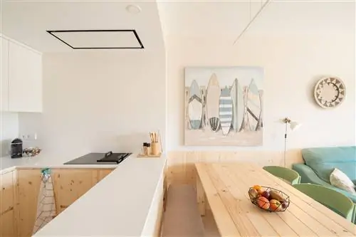 кухня, открытая для столовой, оформлена в белых и деревянных тонах