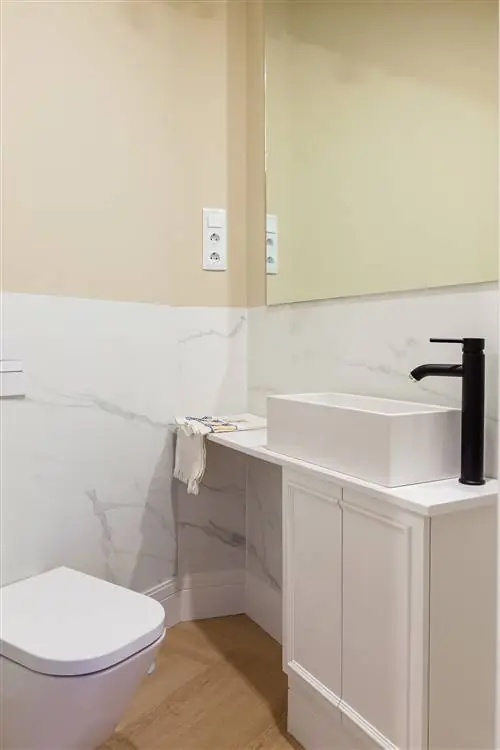 небольшая ванная комната в белом цвете с мраморными стенами