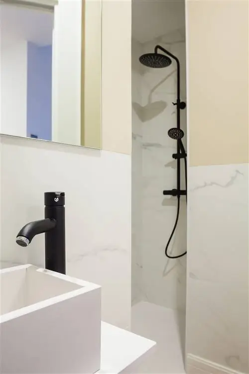 небольшая ванная комната в белом цвете с мраморными стенами