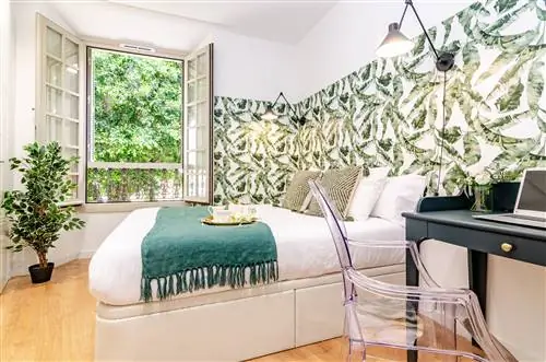 спальня с письменным столом и стеной, украшенной ботаническими обоями