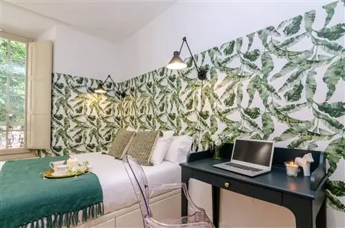 спальня с письменным столом и стеной, украшенной ботаническими обоями