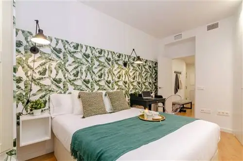 спальня с письменным столом и стеной, украшенной ботаническими обоями