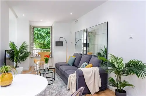 гостиная в элегантном стиле, украшенная растениями и горчичным бархатным креслом