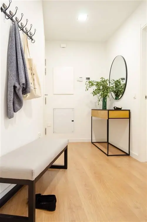 холл с промышленной консолью, круглым зеркалом и скамейкой для обуви