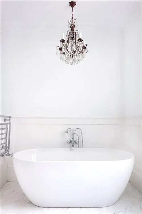 отдельностоящая белая ванна и люстра