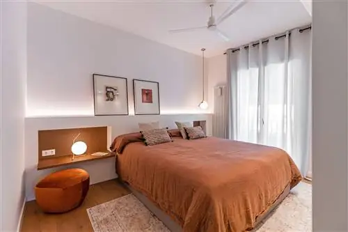 спальня с каменным изголовьем и подвесными деревянными тумбочками