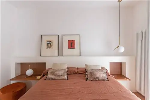 спальня с каменным изголовьем и подвесными деревянными тумбочками