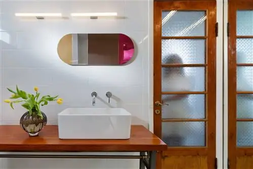 ванная комната со старым деревянным столом и белой керамической раковиной