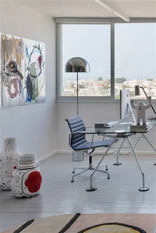 офис со стеклянным столом и абстрактной картиной на стене