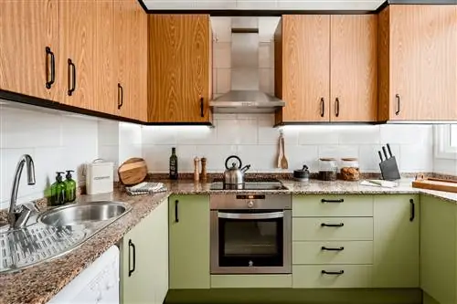 деревенская кухня с деревянными шкафами и окрашена в зеленый цвет