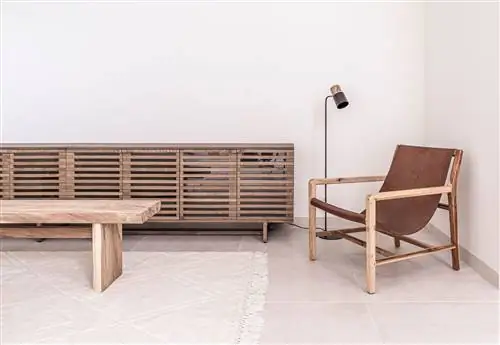 журнальный столик и деревянный буфет и кожаное кресло рядом с торшером