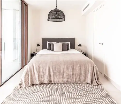 спальня в нейтральных тонах с серым мягким изголовьем