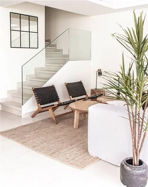 деревянные и плетеные кожаные кресла, деревянные журнальные столики и ковер из волокна