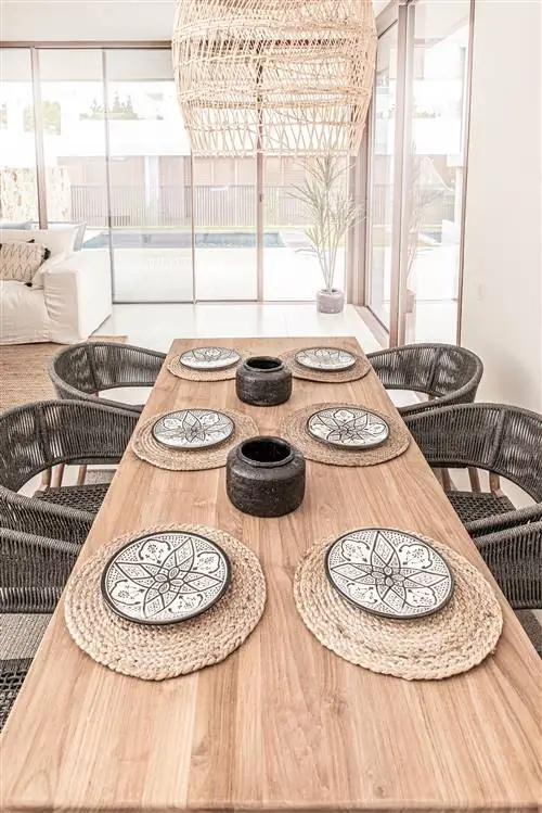 столовая с деревянным столом, стульями и волоконной лампой