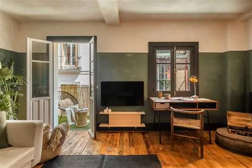 гостиная с письменным столом и выходом на террасу, оформленную в зеленых тонах