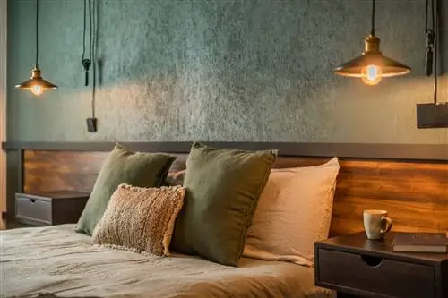 спальня с изготовленным на заказ деревянным изголовьем и стеной с зелеными обоями