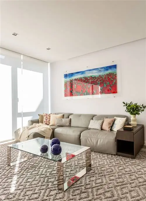 гостиная современного дизайна с серым кожаным диваном-шезлонгом и стеклянным журнальным столиком