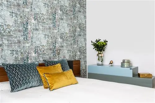 спальня с изготовленным на заказ деревянным изголовьем и состаренными обоями