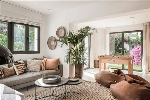 гостиная в нейтральных тонах с серым диваном и коричневыми замшевыми пуфами