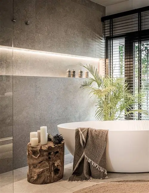 современная ванная комната с отдельно стоящей ванной и деревянным столиком