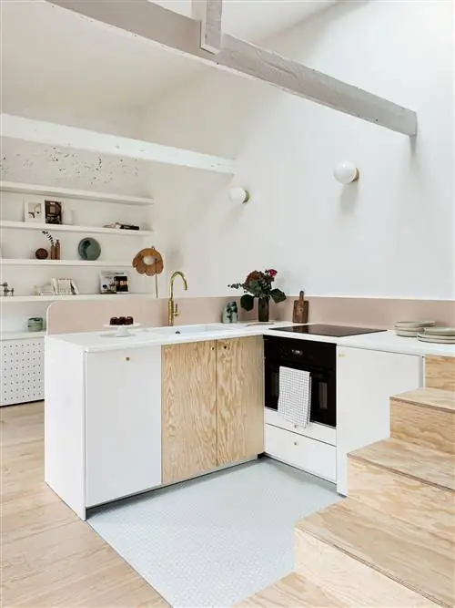 открытая кухня в л с натуральным деревом и белыми шкафами, розовым фасадом и золотым краном