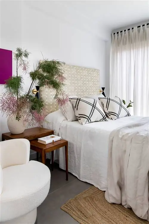 спальня с плетеным изголовьем, деревянными столиками и ковриком из волокна