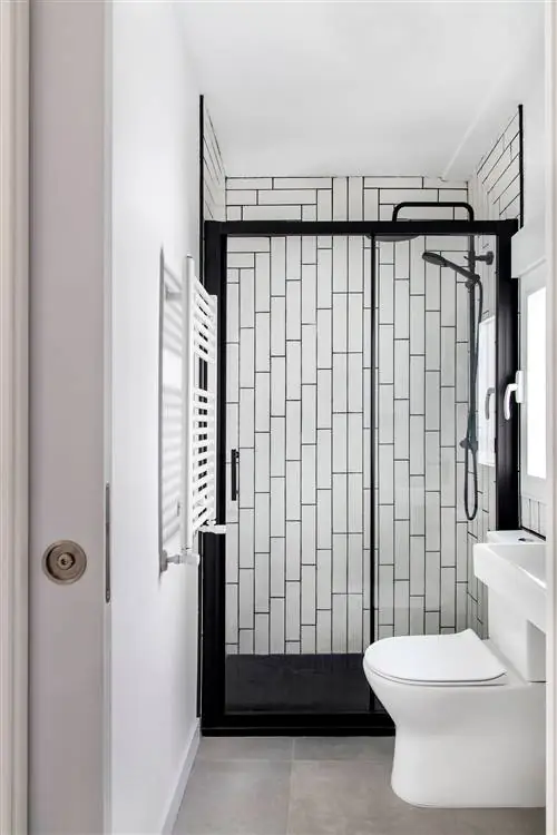 черно-белая ванная комната с душевой кабиной и белой плиткой в стиле метро