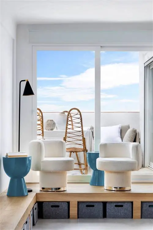 кресла современного дизайна с обивкой из букле, синими тумбочками и выходом на террасу