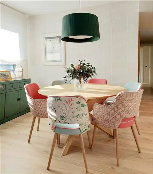 столовая с круглым деревянным столом и стульями с цветочной обивкой