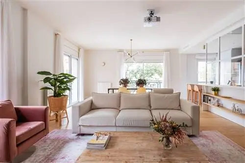 открытая гостиная с бежевым диваном и розовыми бархатными креслами