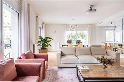 открытая гостиная с бежевым диваном и розовыми бархатными креслами