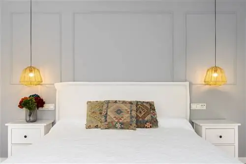 спальня с декоративной лепниной на стенах и льняным изголовьем