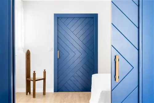 спальня с голубыми дверями и старым деревянным стулом