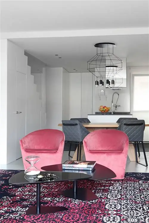 гостиная с розовыми бархатными креслами и журнальными столиками современного дизайна черного цвета