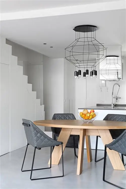 современная открытая кухня в белом цвете с офисом с круглым деревянным столом и серыми мягкими стульями