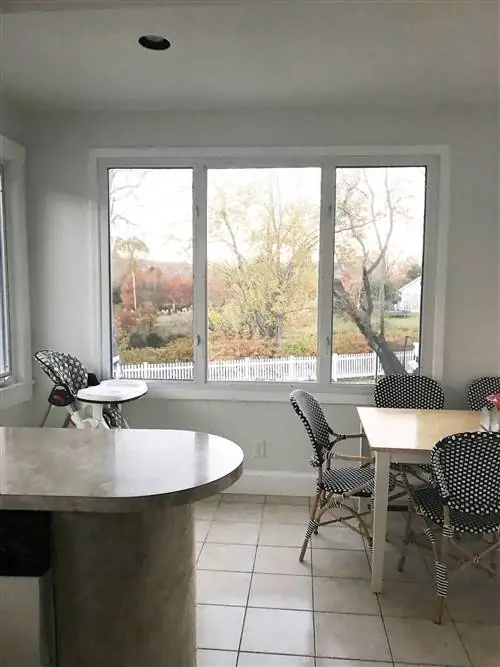 столовая со столом терраццо и деревянными стульями