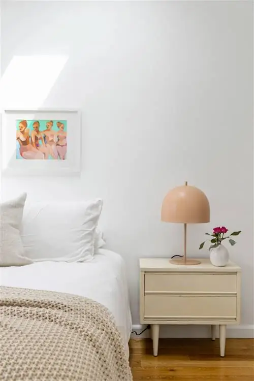 спальня со столом середины века, нюдовой лампой и картиной на стене у изголовья