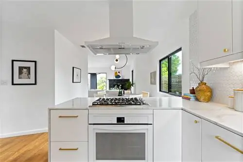 белая кухня открытого плана с полуостровом