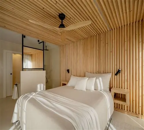 спальня с ванной комнатой и деревянным потолком и облицовкой стен