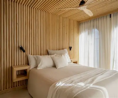 спальня с ванной комнатой и деревянным потолком и облицовкой стен