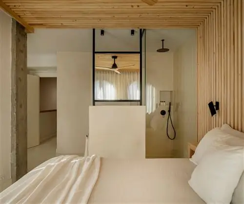 спальня с ванной комнатой и деревянным потолком и облицовкой стен