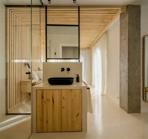 спальня с ванной комнатой и деревянным потолком и облицовкой стен