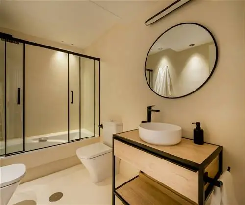 ванная комната с душем, деревянной тумбой и круглым зеркалом в черной раме