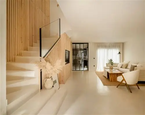 гостиная украшена деревянной мебелью и натуральными волокнами, белым диваном и креслом