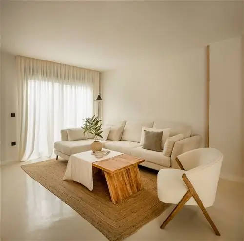 диван с белым шезлонгом, кресло с обивкой из овчины, деревянный журнальный столик и джутовый ковер