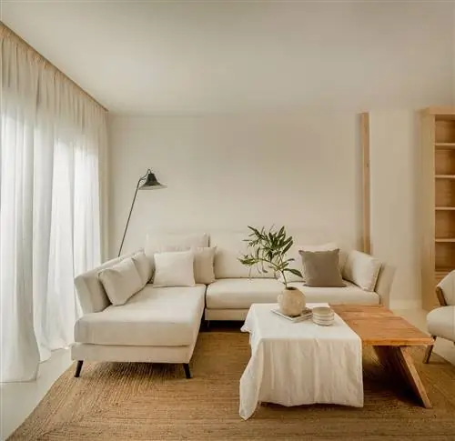 диван с белым шезлонгом, кресло с обивкой из овчины, деревянный журнальный столик и джутовый ковер