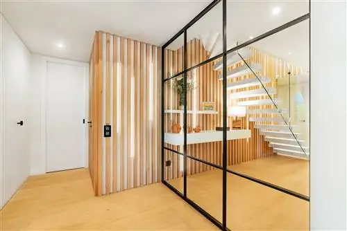 холл с деревянными рейками и стеклянной дверью с металлическими профилями